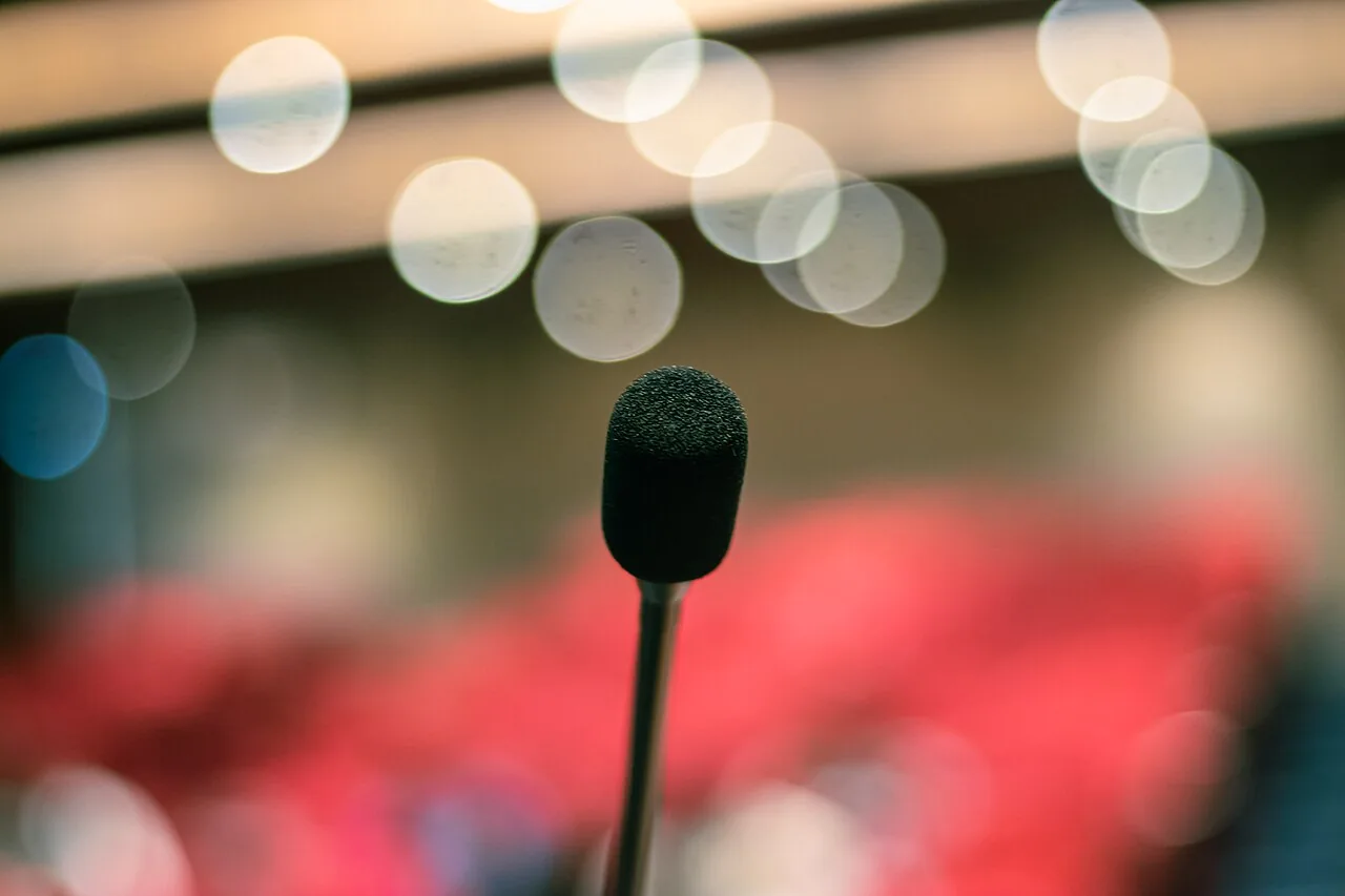 Gooseneck microphone on podium with stage bokeh lights 01